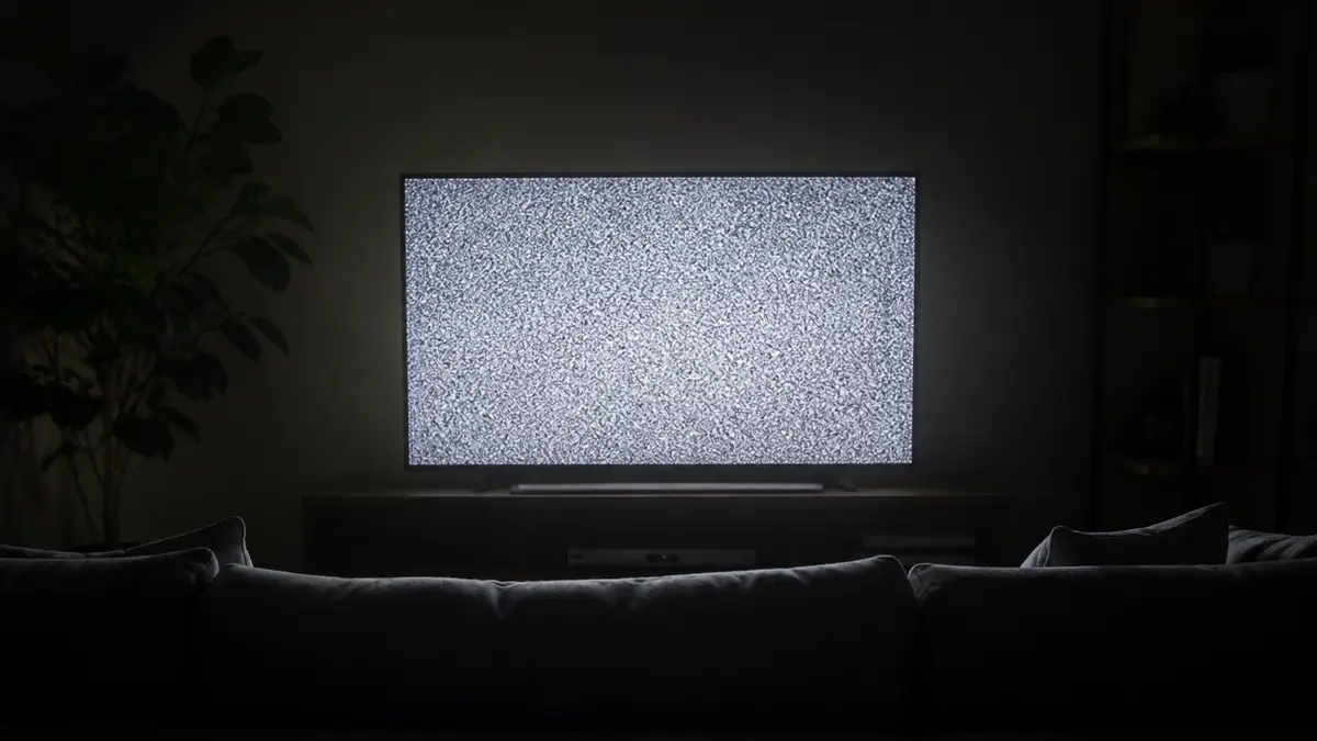 Karanlık odada analog TV karı yayan salon televizyonu, arayüz yazısı yok. Bu statik ekran yalnızca görsel kar, tıslama yok.